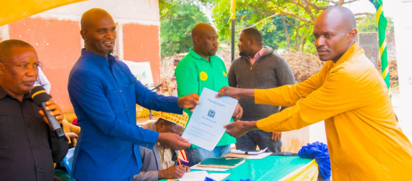 Mkuu wa Wilaya ya Mlele Alhaj Majid Mwanga akikabidhi Hati ya Hakimiliki ya Kimila kwa mwananchi wa Kijiji cha Mtakuja mara baada ya Kijiji hicho kuwezeshwa kuandaa Mpango wa Matumizi ya Ardhi kupitia Mradi wa Usimamzi Shirikishi wa Miombo -DSL IP 10/1/25
