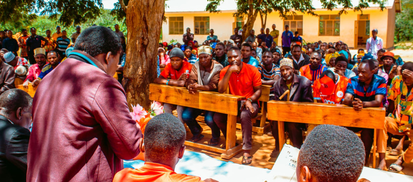 Sehemu ya Wananchi wa Kijiji cha Vitono katika Halmashauri ya Wilaya ya Kilolo, Mkoani Iringa wakimsikiliza kwa Makini Afisa Ardhi kutoka Tume Bw. Otmary Komba akitoa taarifa ya zoezi la uandaaji wa Hati za Hakimiliki za Kimila katika Kijiji hicho 8/3/25