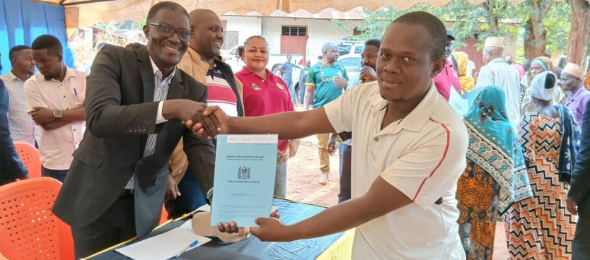 Mkuu wa Wilaya ya Korogwe Mhe. William Mwakilema akikabidhi Hati ya Hakimiliki ya Kimila (CCRO) kwa mmoja wa Wananchi wa Kijiji cha Makumba ikiwa ni hatua mojawapo ya Utekelezaji na Usimamizi wa Mipango ya Matumizi ya Ardhi ya Vijiji 20/07/2025