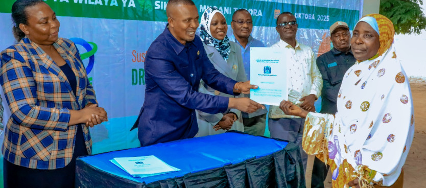 Mkuu wa Wilaya ya Sikonge Mhe. Thomas Myinga akikabidhi Hati ya Hakimiliki ya Kimila kwa mmoja wa wananchi wa Kijiji cha Makibo wakati wa Halfa iliyofanyika katika Kijiji hicho tarehe 25/10/2025. Hati hizo zimewezeshwa kwa ushirikiano wa NLUPC na TFS